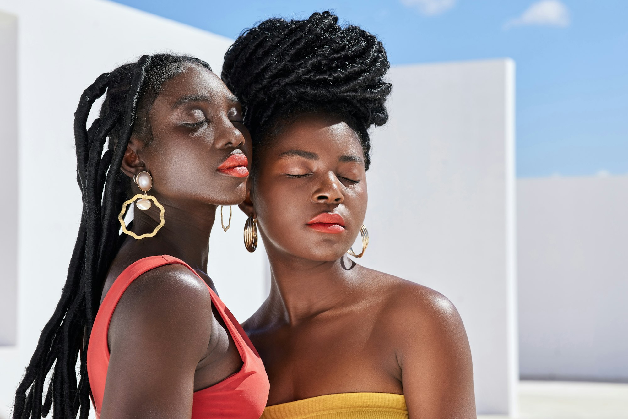 Bright and bold. Cropped shot of two attractive young women posing on a rooftop outdoors.